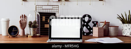 Study corner with laptop with empty screen, fresh plants and decorations on wooden table Stock Photo