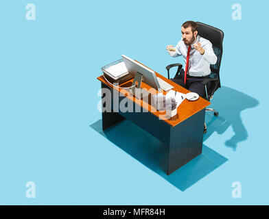suspicious person. Above view of businessman working on laptop. Young distressed frustrated man sitting at office table. Business, workplace concept.  Stock Photo