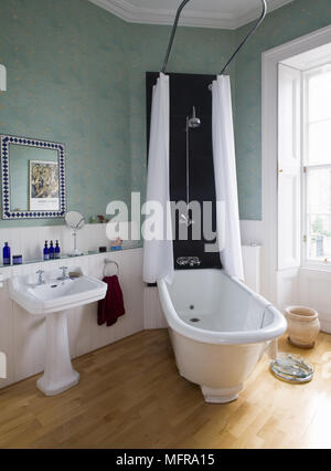 Old fashioned style freestanding roll top bathtub with overhead shower Stock Photo