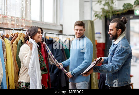 friends choosing clothes at vintage clothing store Stock Photo