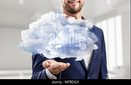 Businessman holding cloud with different digital icons. Stock Photo