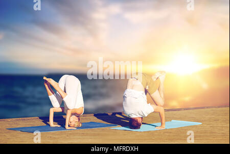 couple doing yoga headstand outdoors Stock Photo