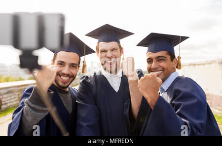 happy male students or graduates taking selfie Stock Photo