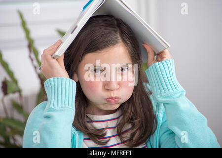 a bored teenage girl is doing her homework Stock Photo