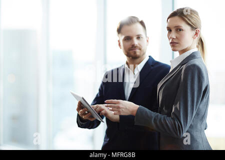 Portrait of young business people using digital tablet together for work Stock Photo