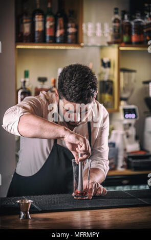 Professional bartender prepare a fresh pomegranate cocktail Stock Photo