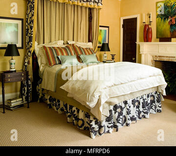 Double bed with fabric canopy in traditional style bedroom Stock Photo