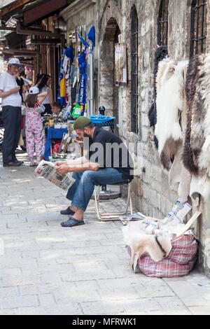 A Muslim man reading in front of Gazi Husrev-beg's Mosque, Sarajevo, Bosnia and Herzegovina Stock Photo