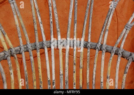 A weaved  cane chair  with an orange background Stock Photo