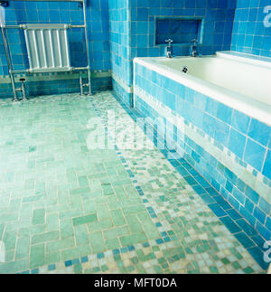 Radiator next to bathtub in blue tiled bathroom Stock Photo