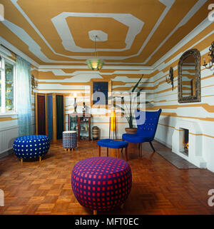 Colourful seating in contemporary sitting room with yellow paint effect on ceiling and walls Stock Photo