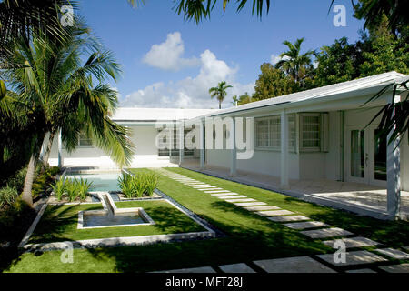 Exterior of American single story house with small swimming pool and palm trees Stock Photo