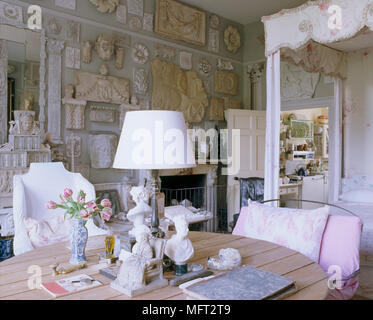 A traditional bedroom, an 18th century four poster bed with fabric canopy, a wood table, display of plaster artifacts on the wall, Stock Photo