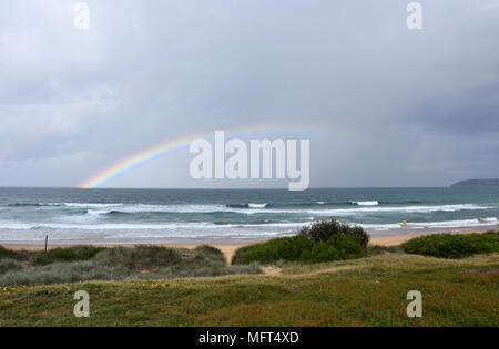 Rainbow over the Tasman sea. Seascape with beautiful multicoloured rainbow over the sea and Curl Curl beach, Australia. Stock Photo