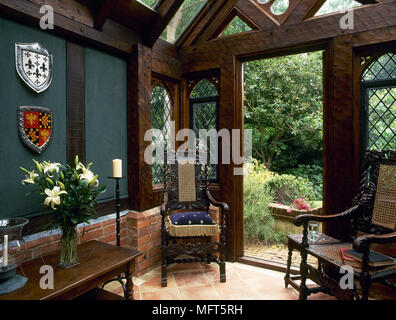 A traditional hallway entrance with gothic styling, carved beams, leaded light windows, coat of arms, Stock Photo