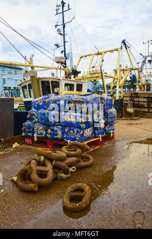 A view of the quayside in portsmouth harbout with large chain links and a pallet piled with plastic lobster pots. Stock Photo