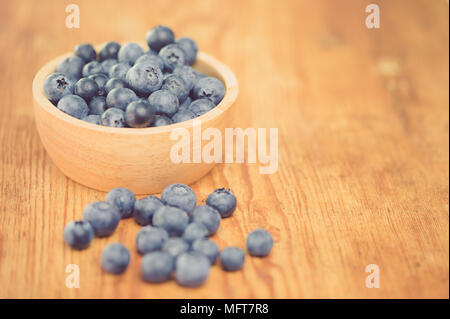 Freshly picked blueberries in wooden bowl.Bilberry on wooden Background. Blueberry antioxidant.Concept for healthy eating and nutrition. Stock Photo