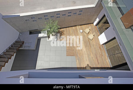 Above view of single tree growing in minimalist courtyard with decked and paved areas Stock Photo