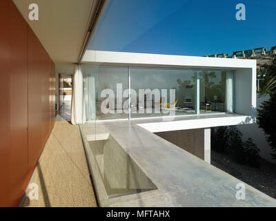 Exterior of modern house set on different levels view to sitting room through ceiling to floor windows Stock Photo