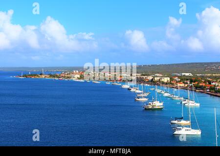 A view from the top of a cruise ship docked in port in Kralendijk, Bonaire, of the surrounding landscape and moored boats nearby. Stock Photo