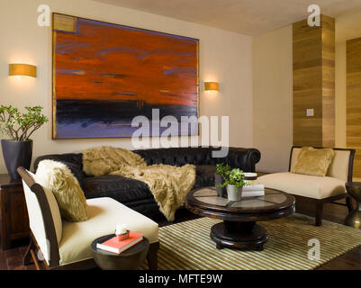 Upholstered seating around coffee table in modern sitting room Stock Photo