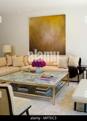 Upholstered seating around coffee table in modern sitting room Stock Photo