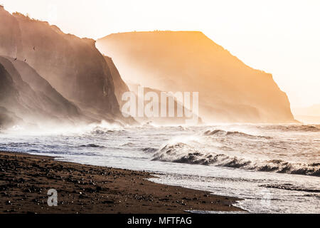 Sunrise on Charmouth beach looking towards Golden Cap. Stock Photo