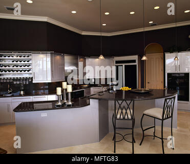 Modern kitchen grey units black granite worktops central island breakfast bar stools  interiors kitchens kitchen-diner diners Stock Photo