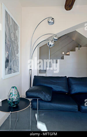 Arc floor lamp next to leather sofa in modern sitting room Stock Photo