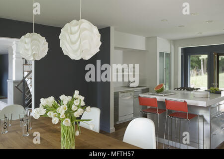 Bar stools at central island breakfast bar in spacious kitchen with dining area Stock Photo