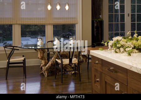Dark wood chairs at glass topped oval table in modern kitchen with dining area Stock Photo
