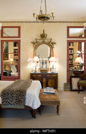 Footstool at foot of double bed in traditional style bedroom Stock Photo