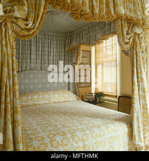 Four poster bed with patterned fabric canopy Stock Photo