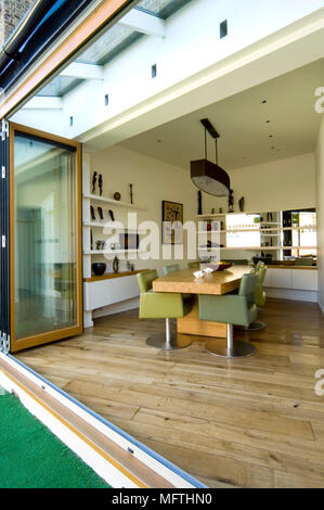 A dining room with doors that open onto a patio and garden Stock Photo ...