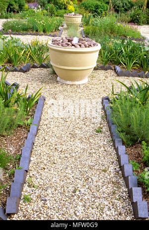 Plant pots set on gravel path with brick edging Stock Photo - Alamy