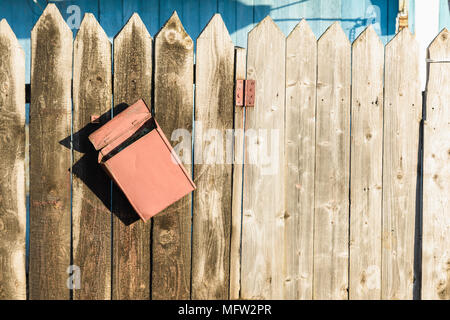 old wooden fence and a crooked rusty letter box Stock Photo