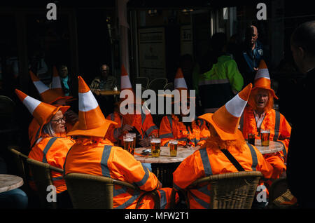 Amsterdam, Netherlands - 27 April, 2017: Group of people wearing orange costumes with hat like traffic cone on Day of the King in Amsterdam Stock Photo