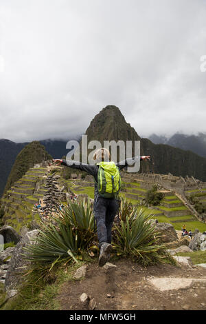 Young woman standing above Machu Picchu Inca citadel in Peru Stock Photo