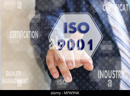 The businessman chooses ISO 9001,  presses a button on the touch screen Stock Photo
