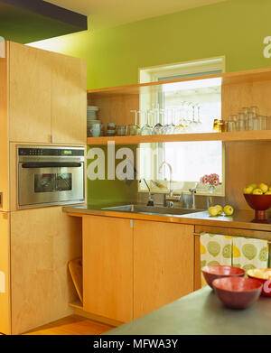 Glass shelving above stainless steel fitted units in modern kitchen ...