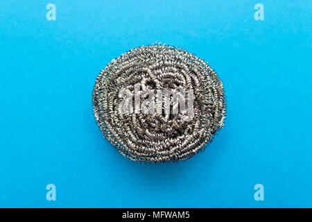 Metal sponge for washing dishes on a blue background Stock Photo