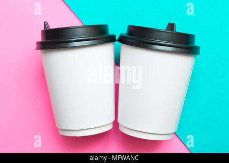 Two disposable cups for hot drinks on a pink and mint geometric backgrounds. Trend colors. Stock Photo