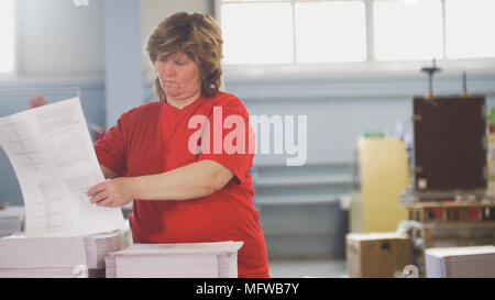 Female workers sorting a paper stacks in the typography Stock Photo