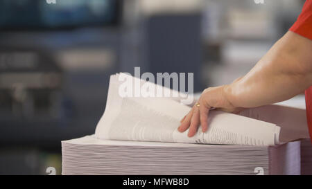 Female hands sorts the stacks of newspapers in typography Stock Photo