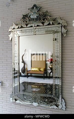 Ornate rectangular mirror reflecting modern seat Stock Photo