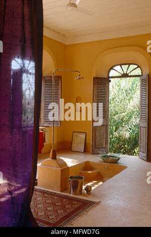 Shower above sunken bath in ethnic styled bathroom Stock Photo