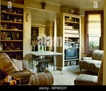 Soft sofa, side table and shelving unit near grey wall in living room ...