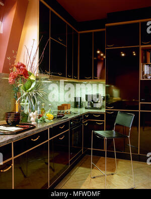 Red kitchen with black lacquered units and granite work top, Stock Photo