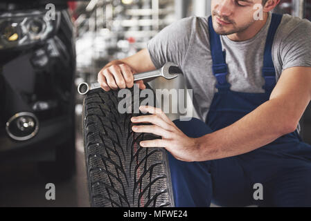 Close up of mechanic showing ok gesture with his thumb while holding a wrench Stock Photo