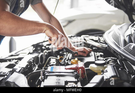 Picture showing muscular car service worker repairing vehicle Stock Photo